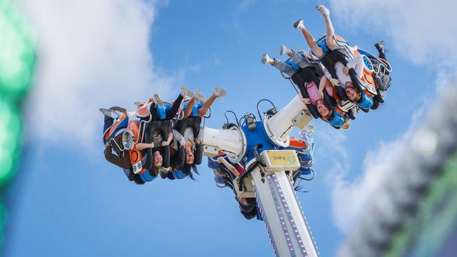 Thrill seekers make the most of the action at People’s Day at the Ekka. Picture Lachie Millard