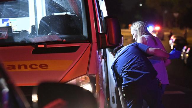 A woman is escorted from the Condell Park home into an ambulance. Picture: Gordon McComiskie