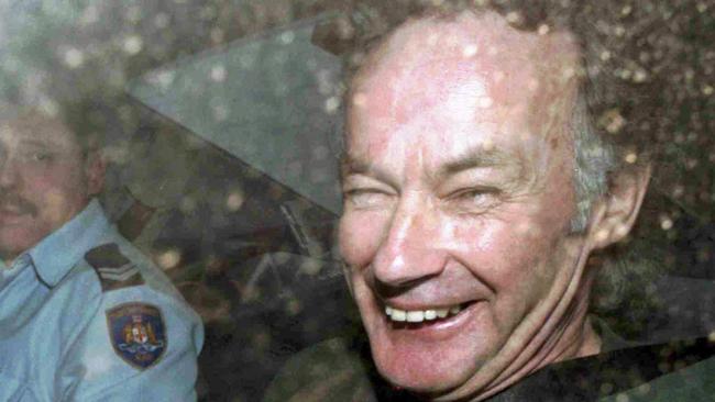 Convicted serial killer Ivan Milat smiles in a police car after attending a court in Sydney in 1997.