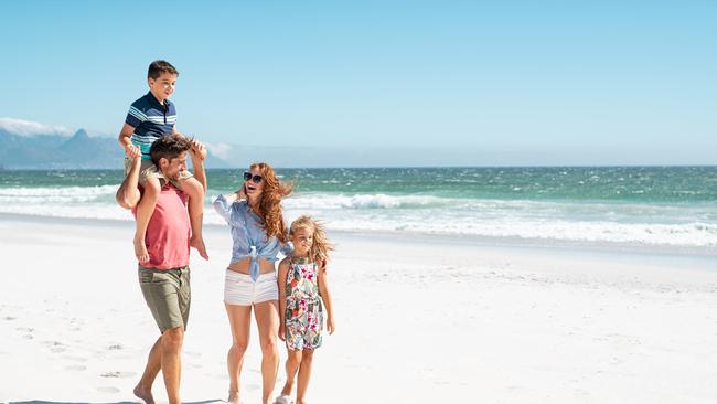 Smiling parents with children at beach.