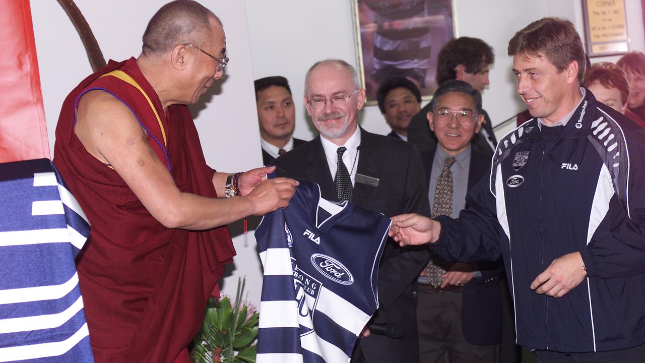 Geelong coach Mark Thompson presents the Dalai Lama with a Cats jumper.