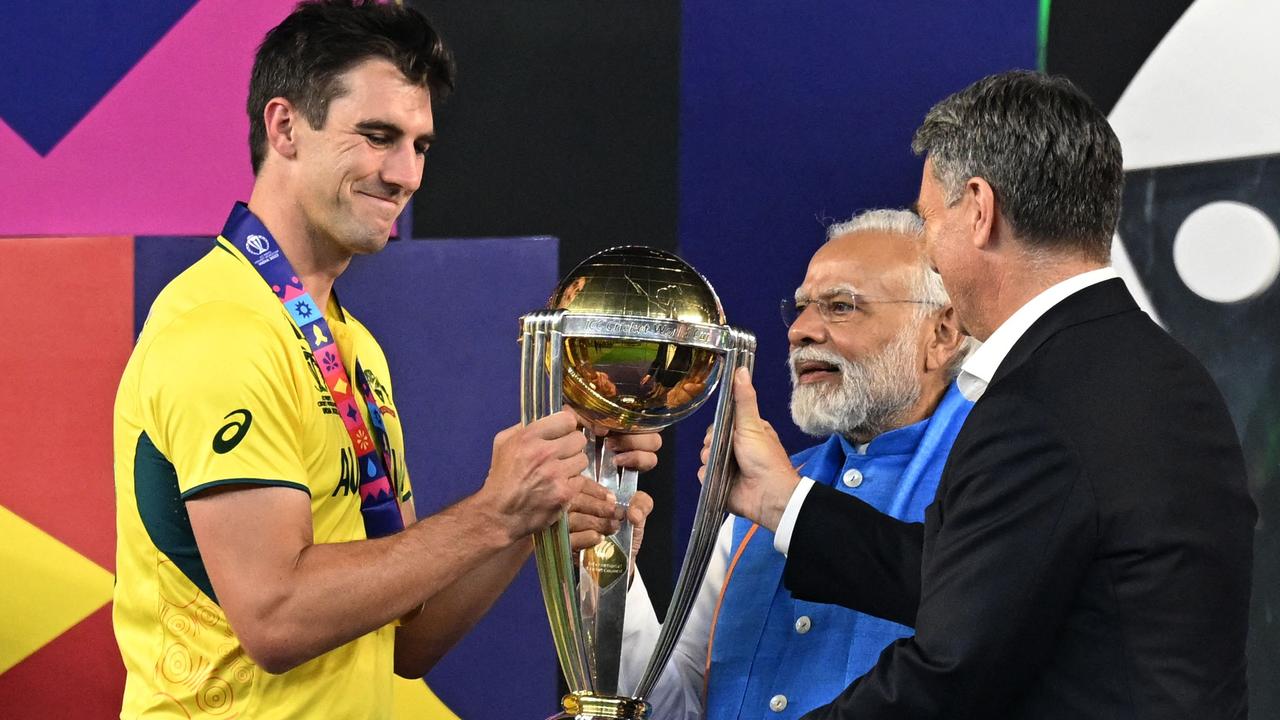 Pat Cummins receives the trophy from Narendra Modi (C) and Richard Marles. Photo: Sajjad HUSSAIN / AFP).