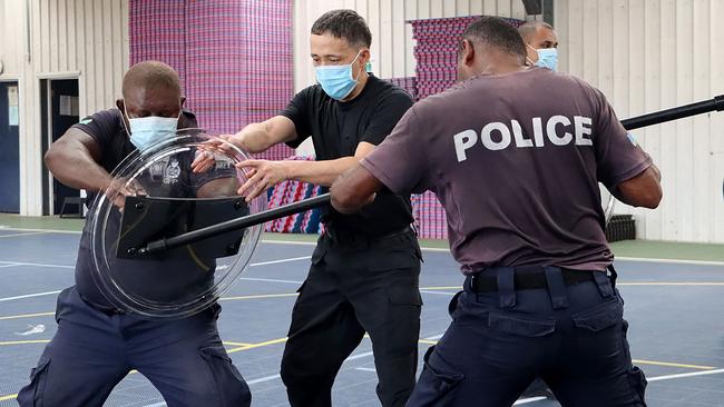 A China Police Liason Team officer (C) trains Solomons police officers in drill, unarmed combat skills and rifle tactics. Picture; AFP.