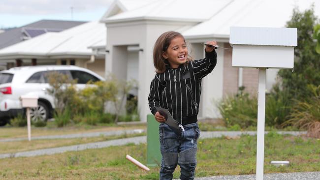 Three-year-old Zaryis Loveridge is delivering pamphlets in the Pimpama area to earn money and he loves it, so long as the letterboxes aren't too high. Picture: Glenn Hampson.