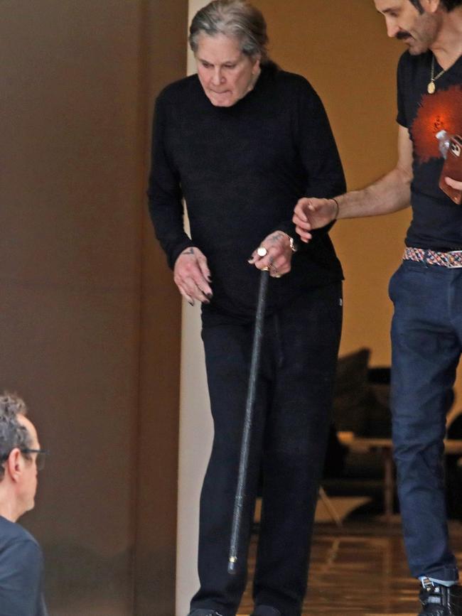 Ozzy Osbourne gets some help down the stairs as he exits Milk Studios in Los Angeles last month. Picture: BACKGRID Australia