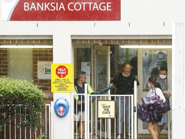 Parents wearing masks arrive to pick their children up from Banksia Cottage Childcare within the Macquarie University Campus. Picture: John Appleyard