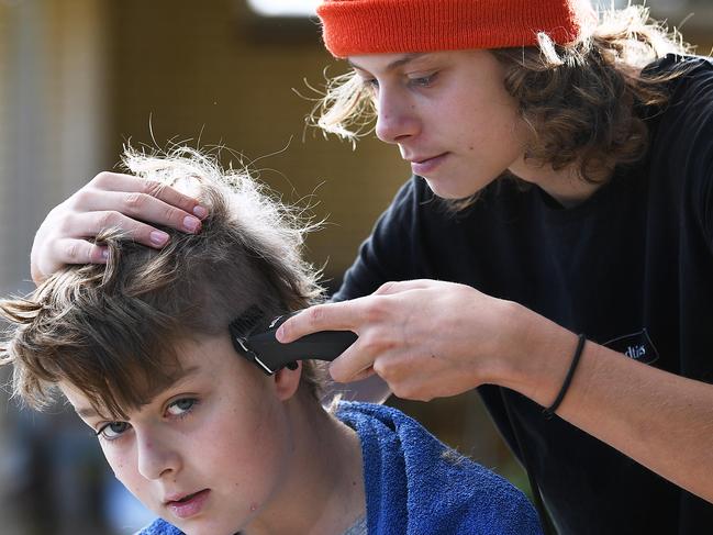 Jacob Stockwell 15 uses clippers to give his younger brother Noah Stockwell 12  his specialty home trained mullet haircut at their Panorama home Wednesday April,22,2020.Picture Mark Brake