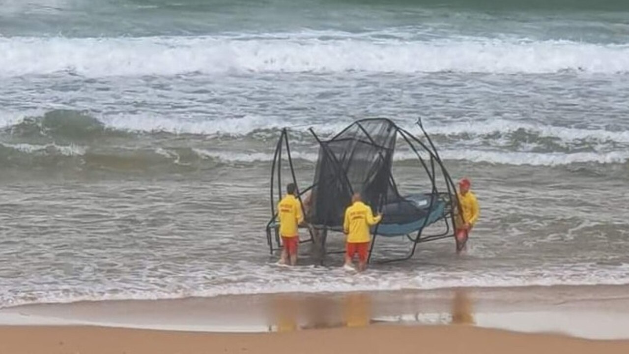 Lifesavers recover the trampoline from the surf.