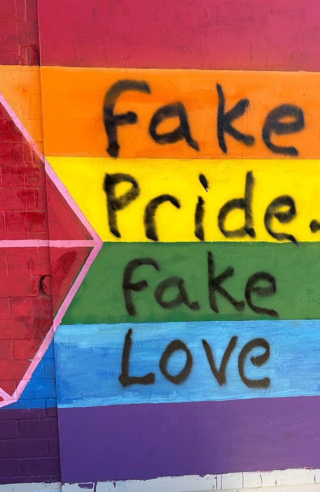 A rainbow flag mural on Austin lane was defaced during the Top End Pride march on Saturday June 24. Volunteers soon after painted over the homophobic slur.