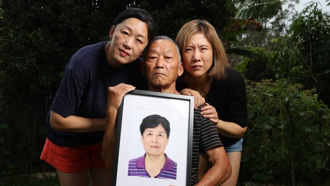 Sisters Na Xue and Fei Xue with their father Zumu Xue who lost their mother and wife Yagin Han, who died on a treadmill at hospital. Picture Lachie Millard