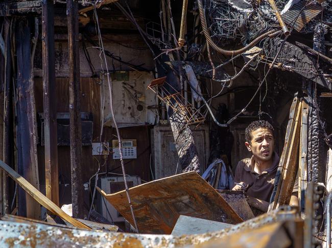 A Moroccan employee looks around the charred wreckage of a Gas station destroyed during last week's rioting which was sparked by the death of George Floyd on June 3, 2020 in Minneapolis, Minnesota. - Former Minneapolis police officer Derek Chauvin, who kneeled on the neck of George Floyd who later died, will now be charged with second-degree murder, and his three colleagues will face charges of aiding and abetting second-degree murder, court documents revealed on June 3. (Photo by Kerem Yucel / AFP)