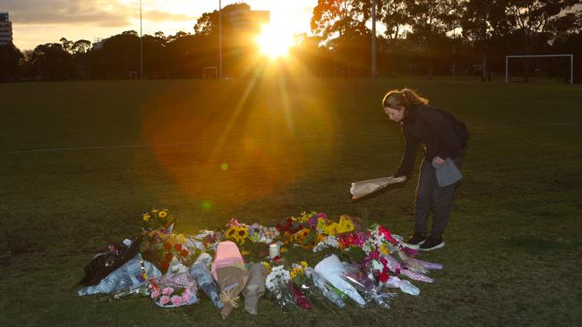 A woman places flowers at a growing makeshift memorial for Eurydice Dixon at Princes Park. Picture: David Crosling/AAP