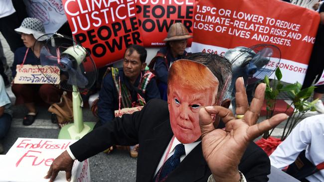 An environmental activist wearing a face-mask depicting US President Donald Trump takes part in a demonstration in front of the United Nations building, where experts from across the planet locked in key talks aimed at breathing life into the Paris Agreement on climate change, in Bangkok on September 8, 2018. - The 2015 Paris deal -- which must be adopted by signatory nations by December 2018-- aims to limit global temperature rises to "well below" two degrees Celsius and to less than 1.5 degrees if possible. (Photo by LILLIAN SUWANRUMPHA / AFP)