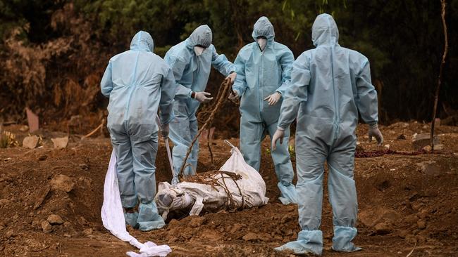 Relatives prepare the burial a COVID-19 victim at a graveyard in New Delhi, India. Picture: AFP