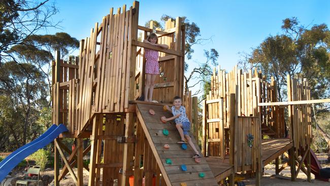Paris Stephens, 9, and Jordon Stephens, 7, enjoy their commercially graded adventure playground at their Monash home which is now for sale. Images supplied.