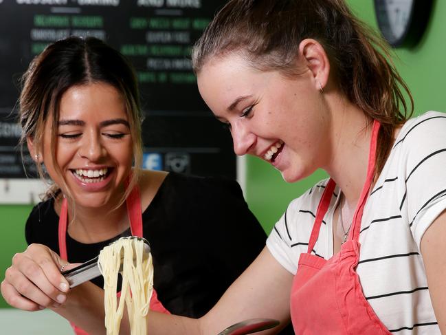 Embargoed for The Saturday TelegraphSydney Cooking School offers cooking classes in Neutral Bay, teaching an adult couple how to boil an egg and cook packet pasta. Alessandra Ortiz, 26, (left) and Kelsey Bennett, 18, learning some skills in the kitchen. Picture: Jonathan Ng