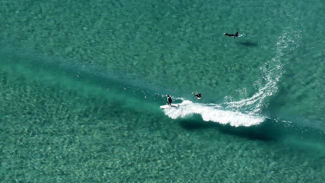 Surfers enjoying a winter surf at Surfers Paradise Beach. Picture: JERAD WILLIAMS