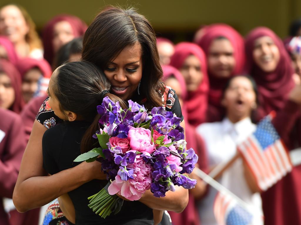 A student gives flowers to, embraces and welcomes with other young students US First Lady Michelle Obama in the courtyard before an event as part of the ‘Let Girls Learn Initiative’ at the Mulberry School for Girls on June 16, 2015 in London, England. Picture: Getty