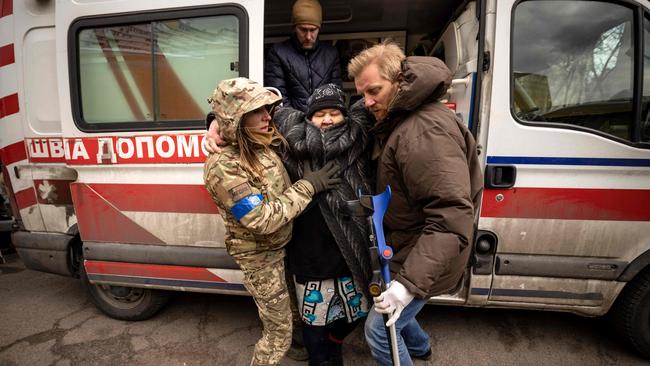 A woman is helped out of an ambulance after fleeing her home in the Kyiv suburb of Stoyanka on March 27. Picture: Fadel Senna/AFP