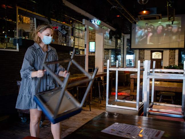 Hotel functions manager Katherine Pullos stacks bar stools as Brisbane enters its three-day lockdown. Picture: AFP