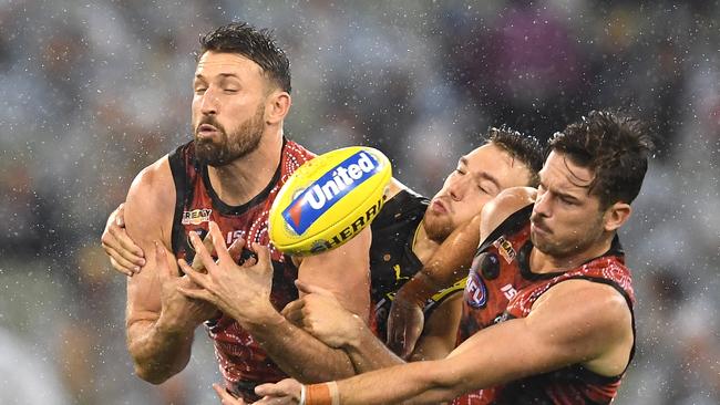 Cale Hooker leads opponent Noah Balta to the ball during a sodden first half at the MCG. Picture: Quinn Rooney/Getty Images.