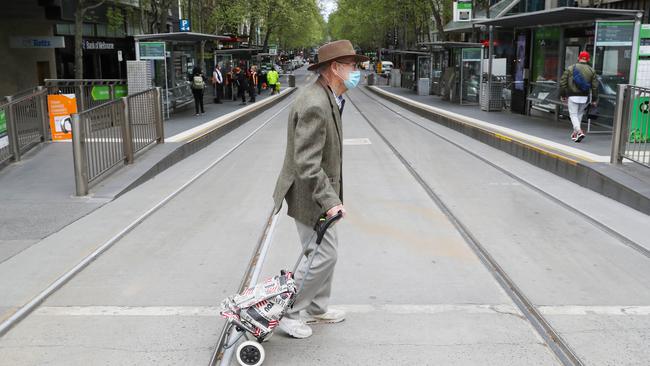 A man crosses Collins Street in the CBD during COVID-19 lockdown in Melbourne. Picture: NCA NewsWire/ David Crosling