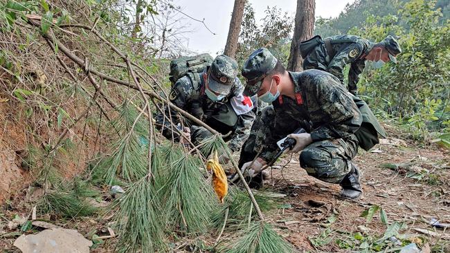 Paramilitary police officers conducting a search at the site of the China Eastern Airlines plane crash. Picture: AFP.