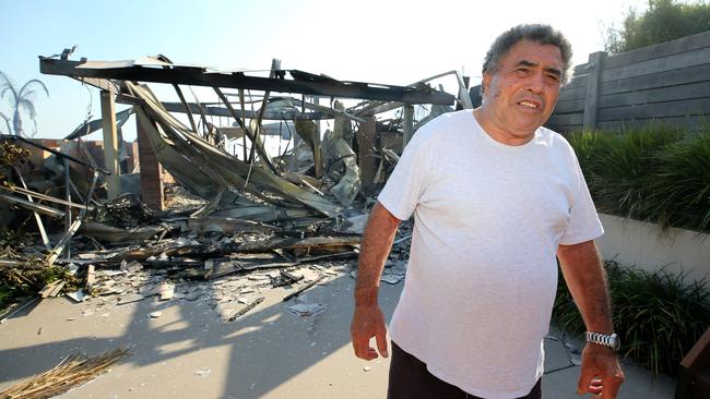 Resident Jimmy Eiuera inspects his friend's destroyed home after yesterday's devastating at Tathra on the NSW South Coast. Pictures: Ray Strange.