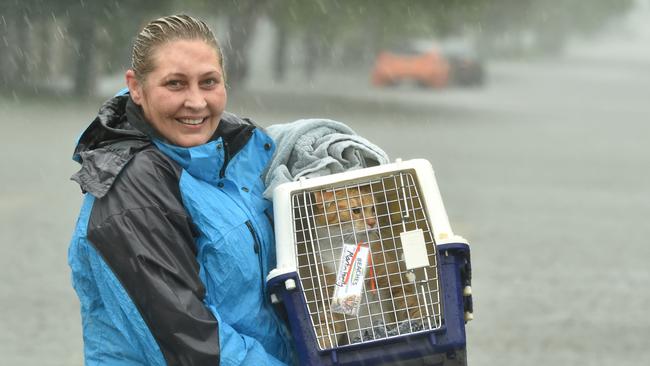 Sunday February 2. Heavy rain lashes Townsville causing flash flooding. Jo Martin carries her cat Kramer in Carmody Street, Rosslea. Picture: Evan Morgan