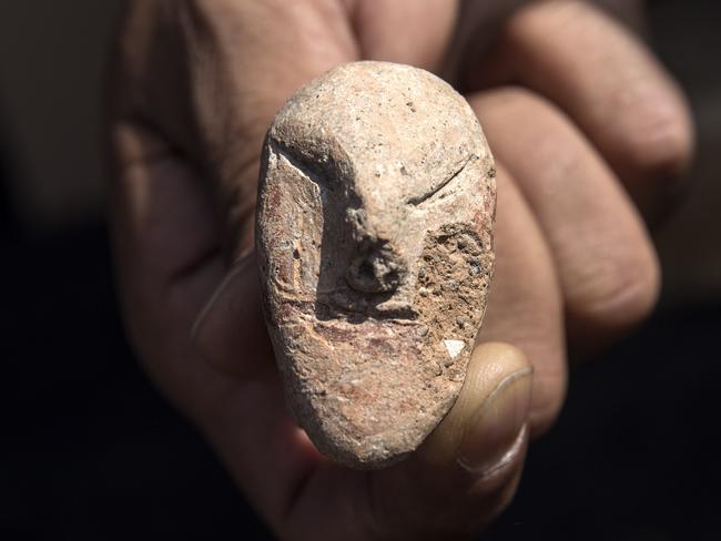 An archeologists shows a figurine found at a large, 5,000-year-old city in northern Israel. Israel's Antiquities Authority said Sunday the ancient city was discovered during preparations for a new highway interchange near Harish, a town roughly 50 kilometers (30 miles) north of Tel Aviv, Sunday, Oct. 6, 2019. (AP Photo/Tsafrir Abayov)