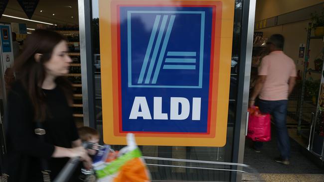 A woman pushes a shoping trolley past an Aldi logo as she leaves one of the company's supermarket stores in London on September 26, 2016. Aldi UK announced on Monday that it will invest £300 million ($389 million, 346 million euros) to revamp its stores over the next three years. Aldi and its German rival Lidl have boomed in Britain, grabbing market share from traditional supermarkets Asda, Morrison, Sainsbury's and Tesco, as customers tightened their belts to save cash. / AFP PHOTO / Daniel Leal-Olivas