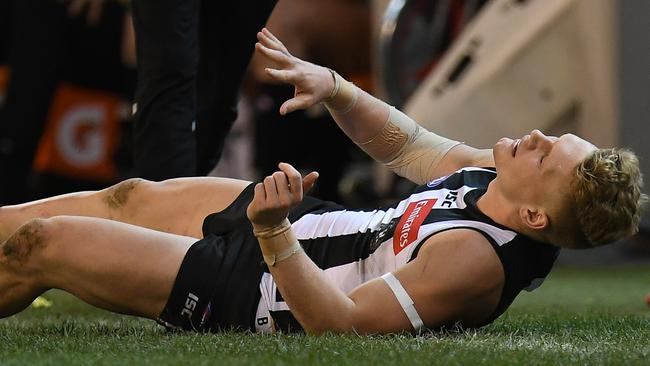 Adam Treloar writhed in pain after suffering a hamstring injury during the Pies’ clash with the Blues. Picture: AAP