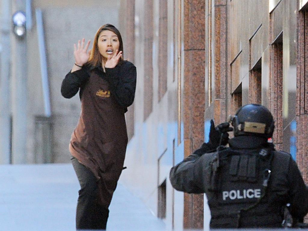 8. Cafe worker Elly Chen, 22, follows John O’Brien out of the door, and races down the street still wearing her brown Lindt barista uniform. Her terrified face confirms the gravity of the situation. Picture: Chris McKeen