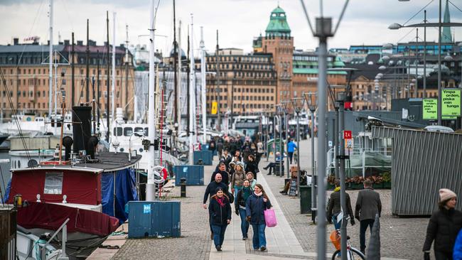 People walk at Strandvagen in Stockholm during the the COVID-19 pandemic.