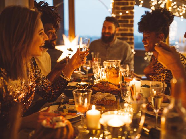 Multi ethnic group of friends having new year dinner party, everyone enjoying in food and drink  - Picture iStock