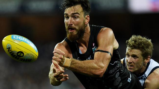 Charlie Dixon gets his handball away in time as he is tackled by Geelong’s Lachie Henderson. Picture: Tracey Nearmy (AAP)