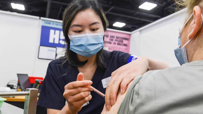 ADELAIDE, AUSTRALIA - NewsWire Photos NOVEMBER 4, 2021: SA Health vaccinator Xuan gives paramedic Sharon Hennessy a Covid booster vaccine at Wayville Vaccination Clinic. Picture: NCA NewsWire/Brenton Edwards