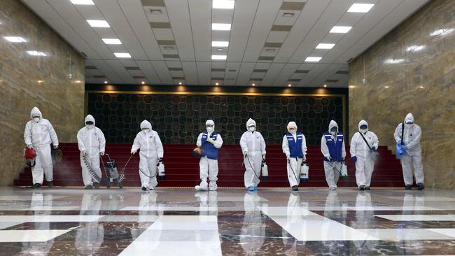 Workers from the Korea Pest Control Association spray disinfectant as part of preventive measures against the spread of the COVID-19 coronavirus, at the National Assembly in Seoul. Picture: AFP