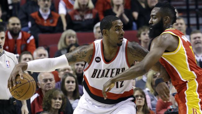 Portland Trail Blazers forward LaMarcus Aldridge works the ball in against Houston Rockets guard James Harden.