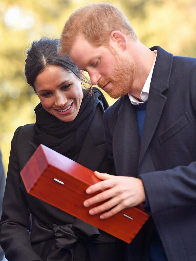 Prince Harry and his fiancée Meghan Markle open a wedding gift from Harry Smith and Megan Taylor, both from Marlborough Primary School, during their visit to Cardiff Castle on January 18, 2018 in Cardiff, Wales. Picture: Getty