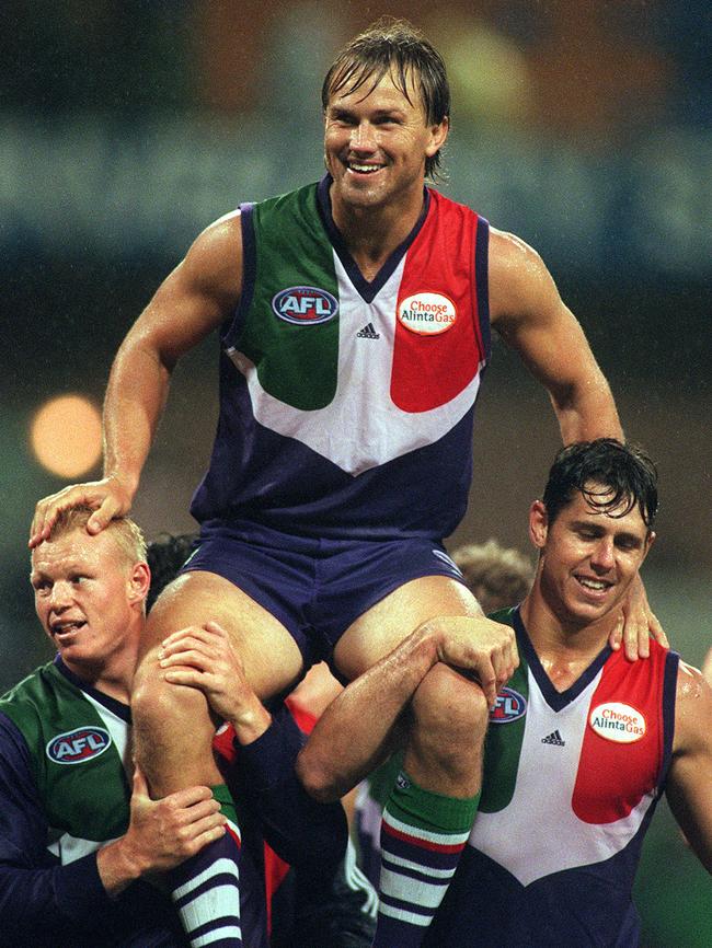 Footballer Tony Modra being carried off ground after his 150th match by Clive Waterhouse and Brendon Fewster in July 2000.