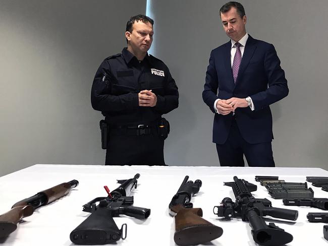 Justice Minister Michael Keenan examines a range of weapons after announcing the first national gun amnesty since the one that followed the Port Arthur massacre. Picture: Caroline Schelle / AAP