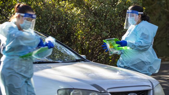 Nurses are seen doing COVID-19 testing at a drive-thru fever clinic in Ipswich on August 24. Health workers who have gone above and beyond for the state will get two days’ extra leave. (Photo by Glenn Hunt/Getty Images)