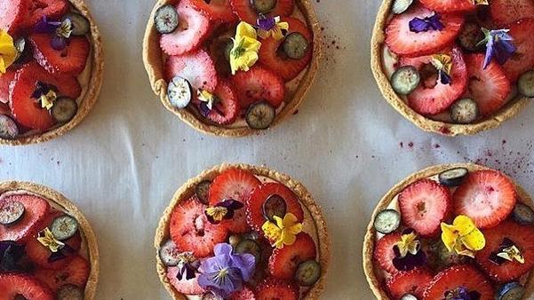 Spelt tarts with orange vanilla cream, strawberries and edible flowers.