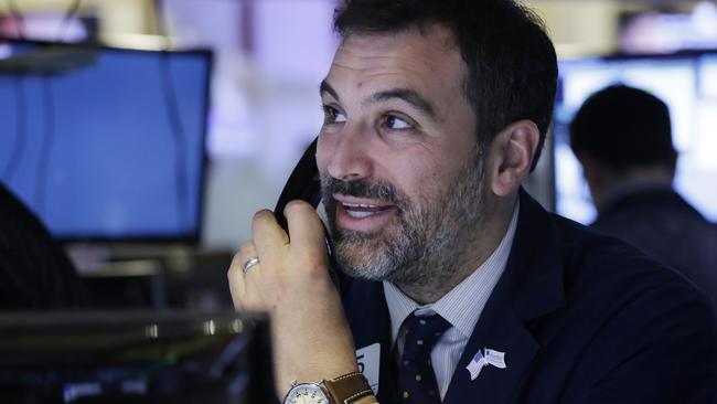 A trader smiles as he follows prices before the opening bell at the New York Stock Exchange, Friday, Jan. 22, 2016. (AP Photo/Mark Lennihan)