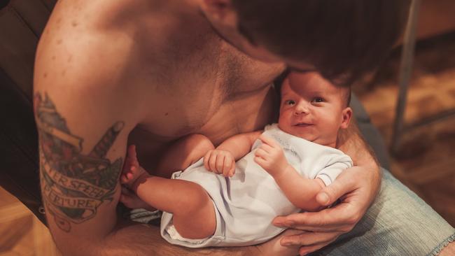 Cute newborn baby feet in father hands