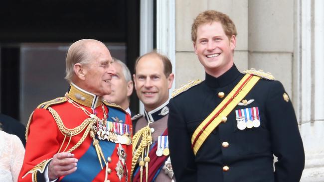 Prince Harry and Prince Philip, Duke of Edinburgh share a joke on the balcony during Trooping the Colour in 2014. Picture: Getty