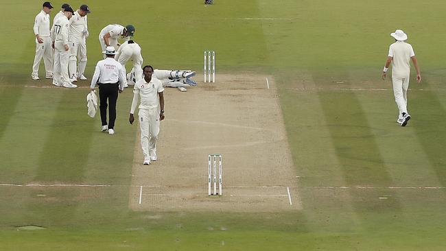 England players crowd around Smith to check on him after he was hit by an Archer bouncer.