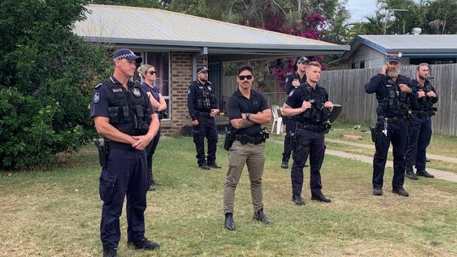 Police stand guard at a Norman Gardens home after a group rallied out front.