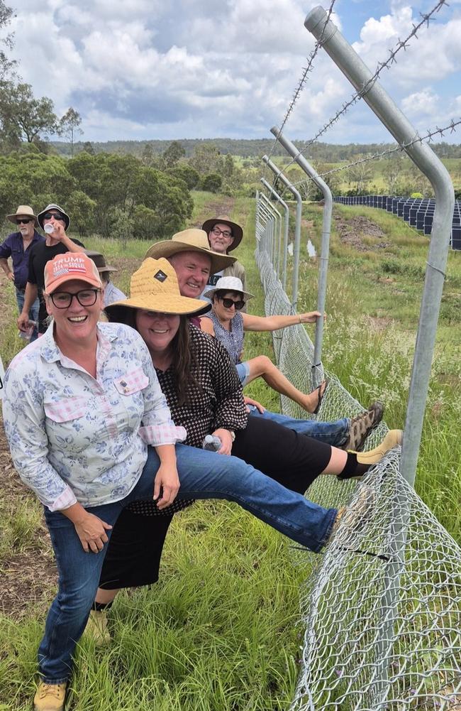 Protesters remove part of the new 1.8m high boundary fence on landowner Michelle Hunt's (second left) property at Bullyard, near Gin Gin in Queensland, after it was erected without her permission by the neighbouring solar farm. She says the original farm fence was ripped out and burned without her knowledge and she wants the new security fence moved onto the solar farm's land, as per the development conditions. About 70 people came from throughout south-east Qld to help remove half of the fence